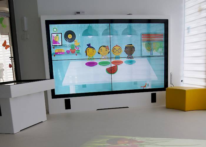 Sala multimedialna w przedszkolu Pod Magnolią, dotykowa ścianka z monitorów bezszwowych i stół interaktywny